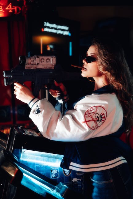 A woman dressed in a white jacket with a red logo on the sleeve is indoors, engaged in a home relocation activity. She is holding a realistic-looking replica rifle with both hands, aiming it forward, and has a cigar in her mouth. The background features a television or monitor displaying some text, along with dim ambient lighting and a red curtain. The scene suggests a staged or themed setting related to entertainment or gaming, with no furniture or household items visible, focusing solely on the woman and her costume.